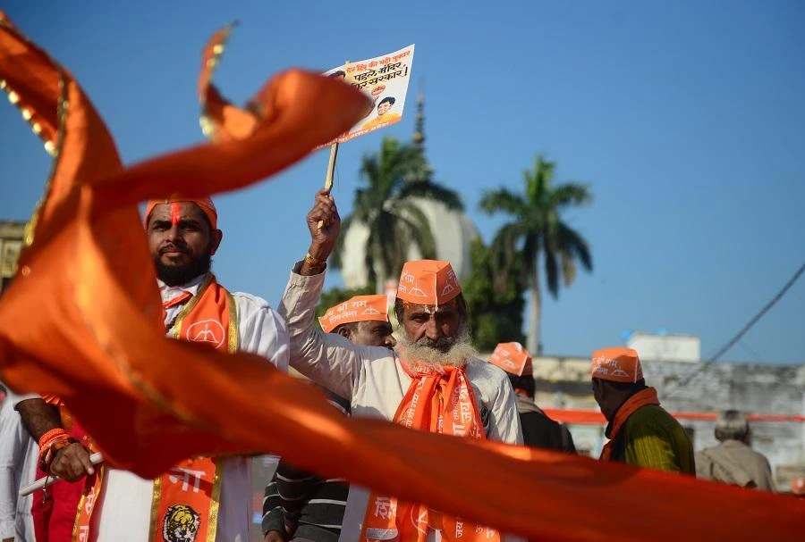 Shiv Sena activists wave a flag at Lakshman Qila during an event for the construction of Ram temple in Ayodhya on Nov. 24, 2018. (Sanjay Kanojia/AFP)