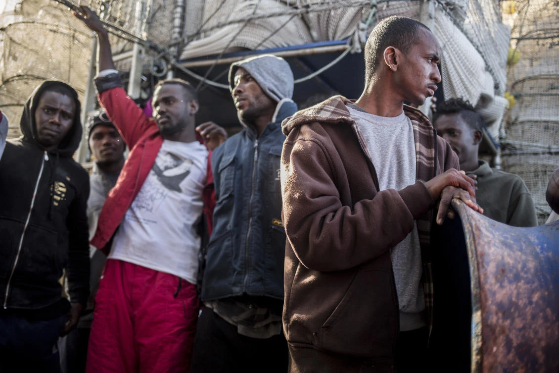 In this photo taken on Saturday, Nov. 24, 2018 photo, Migrants from Somalia, Nigeria, Sudan, Senegal and Egypt stand on the deck of Nuestra Madre de Loreto, a Spanish fishing vessel, after being rescued two days ago off the Libyan coast. (AP)