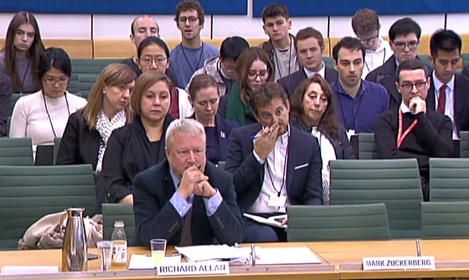 A still image taken from video footage broadcast by the UK Parliament's Parliamentary Recording Unit (PRU) on November 27, 2018 shows Richard Allan (L), Vice President of Policy Solutions, Facebook, seated next to a vacant seat for Facebook Chief Executive Mark Zuckerberg, who declined the invitation to attend. (AFP)