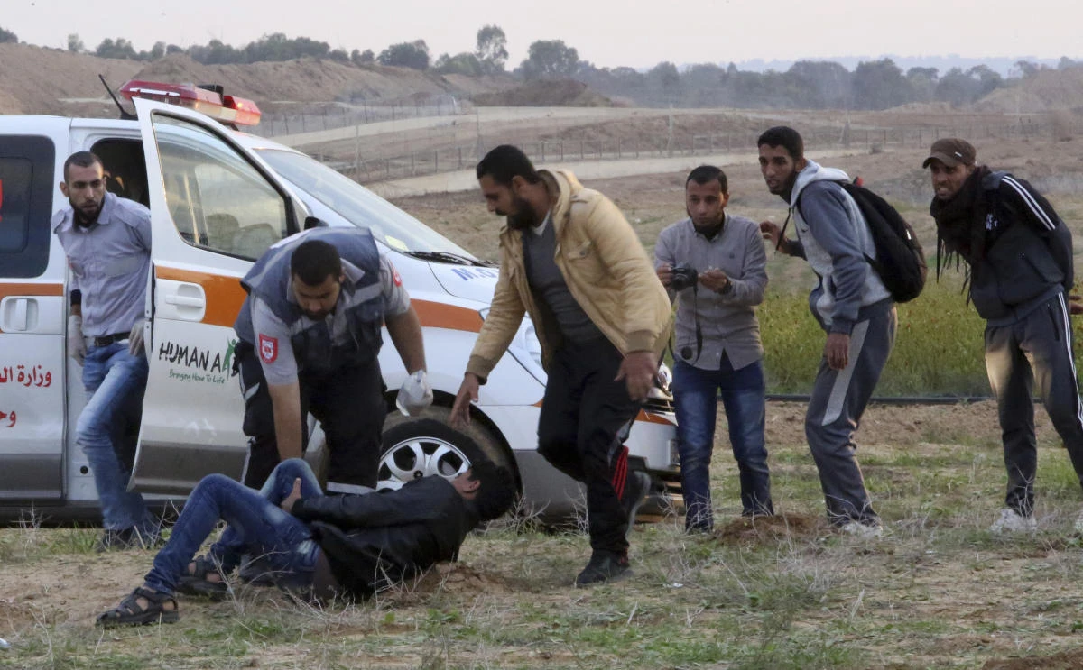 Medics and protesters run to evacuate a wounded youth from near the fence of the Gaza Strip border with Israel during a protest east of Gaza City, Friday, Nov. 16, 2018. (AP)