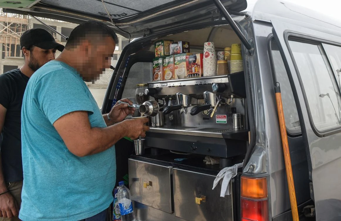 A Syrian refugee prepares coffee at the back of an improvised food truck in the Egyptian capital Cairo on October 23, 2018. (AFP)