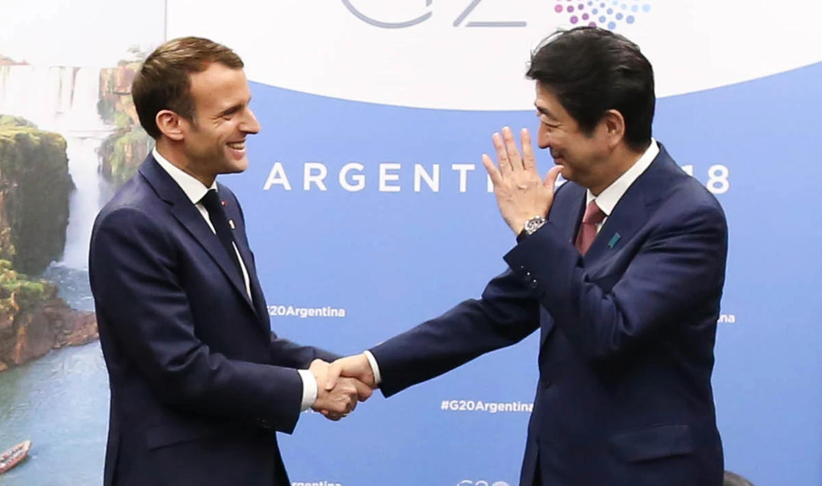 France’s President Emmanuel Macron (L) and Japan’s Prime Minister Shinzo Abe shake hands during a meeting in the sidelines of the G20 Leaders’ Summit in Buenos Aires, on November 30, 2018. (AFP)