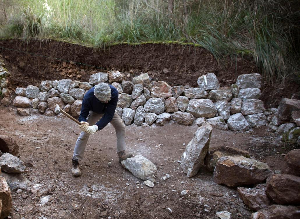 A man uses the dry stone technique to biuld a wall in Esporles on the Spanish Balearic Island of Mallorca on December 11, 2018. The art of dry stone walling, inscribed in 2018 on the Representative List of the Intangible Cultural Heritage of Humanity, (sometimes called drystack) is a building method by which structures are constructed from stones without any mortar to bind them together. Dry stone structures are stable because of their unique construction method, which is characterized by the presence of a load-bearing facade of carefully selected interlocking stones. / AFP / JAIME REINA