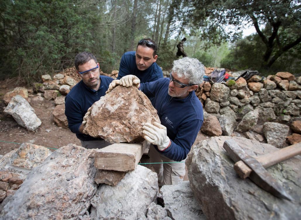 Some men build a wall using the dry stone technique in Esporles on the Spanish Balearic Island of Mallorca on December 11, 2018. The art of dry stone walling, inscribed in 2018 on the Representative List of the Intangible Cultural Heritage of Humanity, (sometimes called drystack) is a building method by which structures are constructed from stones without any mortar to bind them together. Dry stone structures are stable because of their unique construction method, which is characterized by the presence of a load-bearing facade of carefully selected interlocking stones. / AFP / JAIME REINA