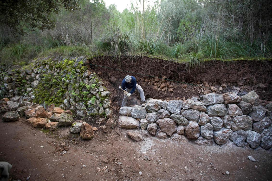 A man uses the dry stone technique to biuld a wall in Esporles on the Spanish Balearic Island of Mallorca on December 11, 2018. The art of dry stone walling, inscribed in 2018 on the Representative List of the Intangible Cultural Heritage of Humanity, (sometimes called drystack) is a building method by which structures are constructed from stones without any mortar to bind them together. Dry stone structures are stable because of their unique construction method, which is characterized by the presence of a load-bearing facade of carefully selected interlocking stones. / AFP / JAIME REINA