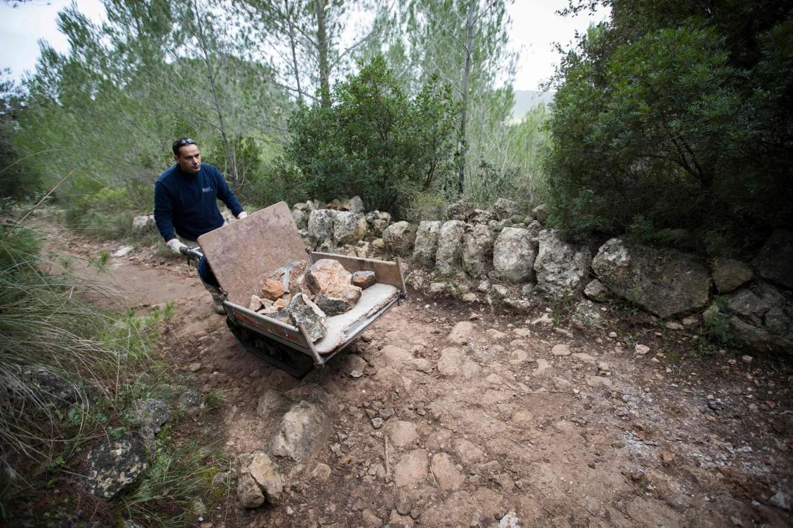 A man uses the dry stone technique to biuld a wall in Esporles on the Spanish Balearic Island of Mallorca on December 11, 2018. The art of dry stone walling, inscribed in 2018 on the Representative List of the Intangible Cultural Heritage of Humanity, (sometimes called drystack) is a building method by which structures are constructed from stones without any mortar to bind them together. Dry stone structures are stable because of their unique construction method, which is characterized by the presence of a load-bearing facade of carefully selected interlocking stones. / AFP / JAIME REINA