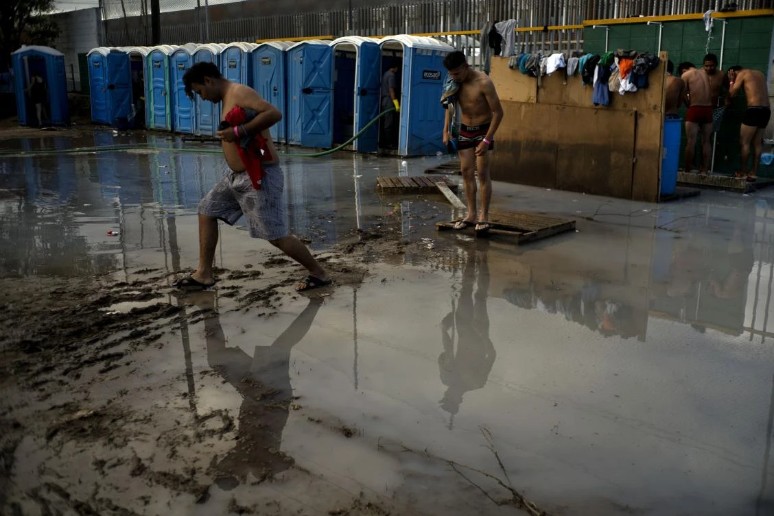 Caravan migrants in Mexico fill new border shelter after rains force exodus