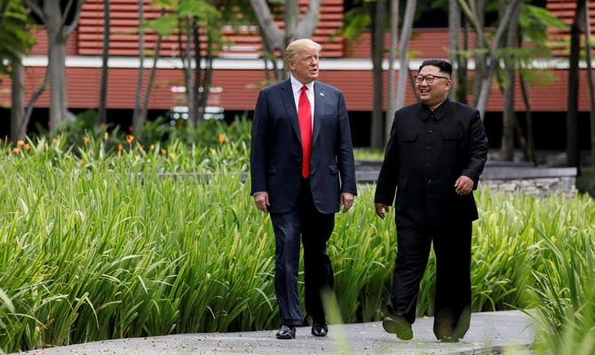 US President Donald Trump and North Korea’s leader Kim Jong Un walk together before their working lunch during their summit at the Capella Hotel on the resort island of Sentosa, Singapore, on June 12, 2018. (REUTERS/Jonathan Ernst/File Photo)