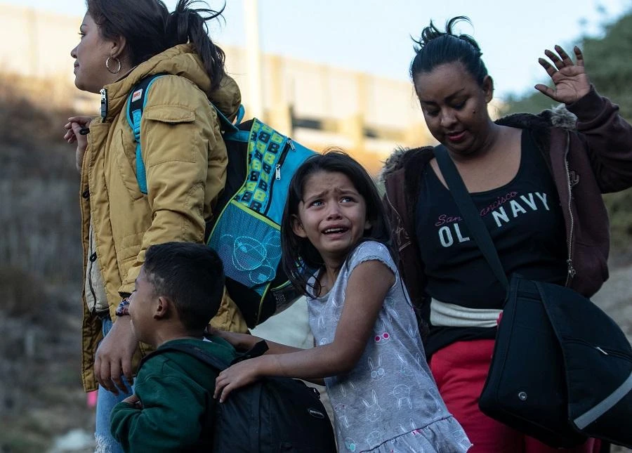 A girl cries as a group of Central American migrants surrender to US Border Patrol agents after jumping over the metal barrier separating Playas de Tijuana in Mexico from the United States, on December 2, 2018. (AFP)
