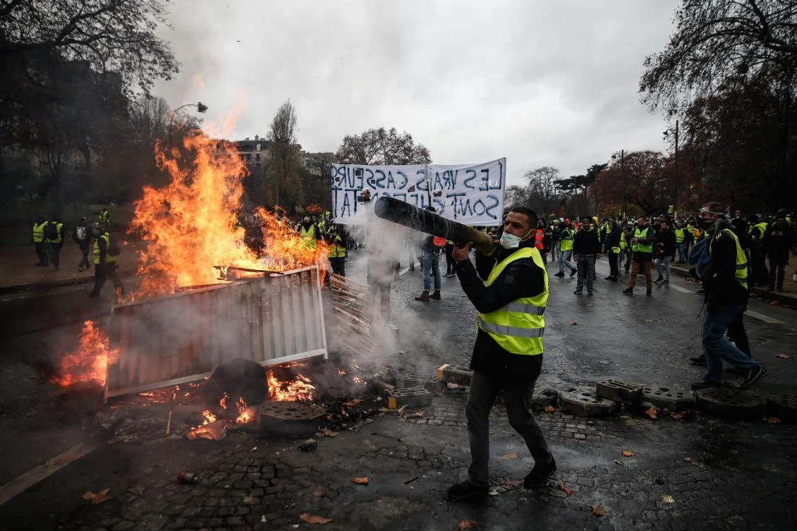 Protesters build a barricade during a protest of Yellow vests (Gilets jaunes) against rising oil prices and living costs, on December 1, 2018 in Paris. (AFP)