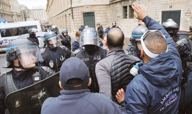 Ambulance workers face riot police officers outside the National Assembly in Paris on Monday. (AP)