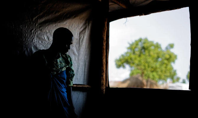 In this Saturday, June 3, 2017 file photo, a South Sudanese refugee and 32-year-old mother, who said she was raped for several days by a group of soldiers before she was allowed to leave, stands by a window at a women's center focusing on gender-based violence, run by the aid group International Rescue Committee, in Bidi Bidi, Uganda. (AP)