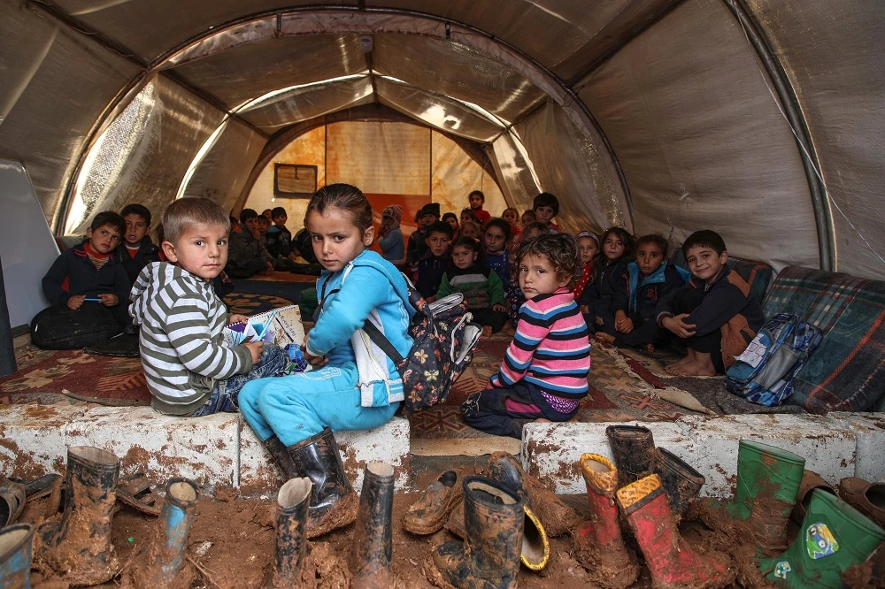 Syrian children gather in a tent repurposed as a make-shift classroom, at a camp for the displaced near the town of Sarmada in the northern countryside of the rebel-held Idlib province on December 1, 2018. (File/ AFP)