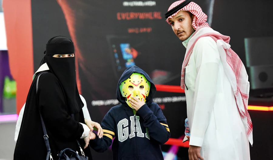 A Saudi family accompanies their child, who is wearing a Jason Voorhees hockey mask during an entertainment event in Riyadh. (AFP)