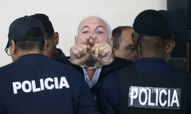 Panama's former President Ricardo Martinelli yells out to journalists that President Juan Carlos Varela is interfering in his case and wants him jailed for life, as he is escorted by police during a recess from his court hearing in Panama City, Monday, Nov. 19, 2018. (AP)