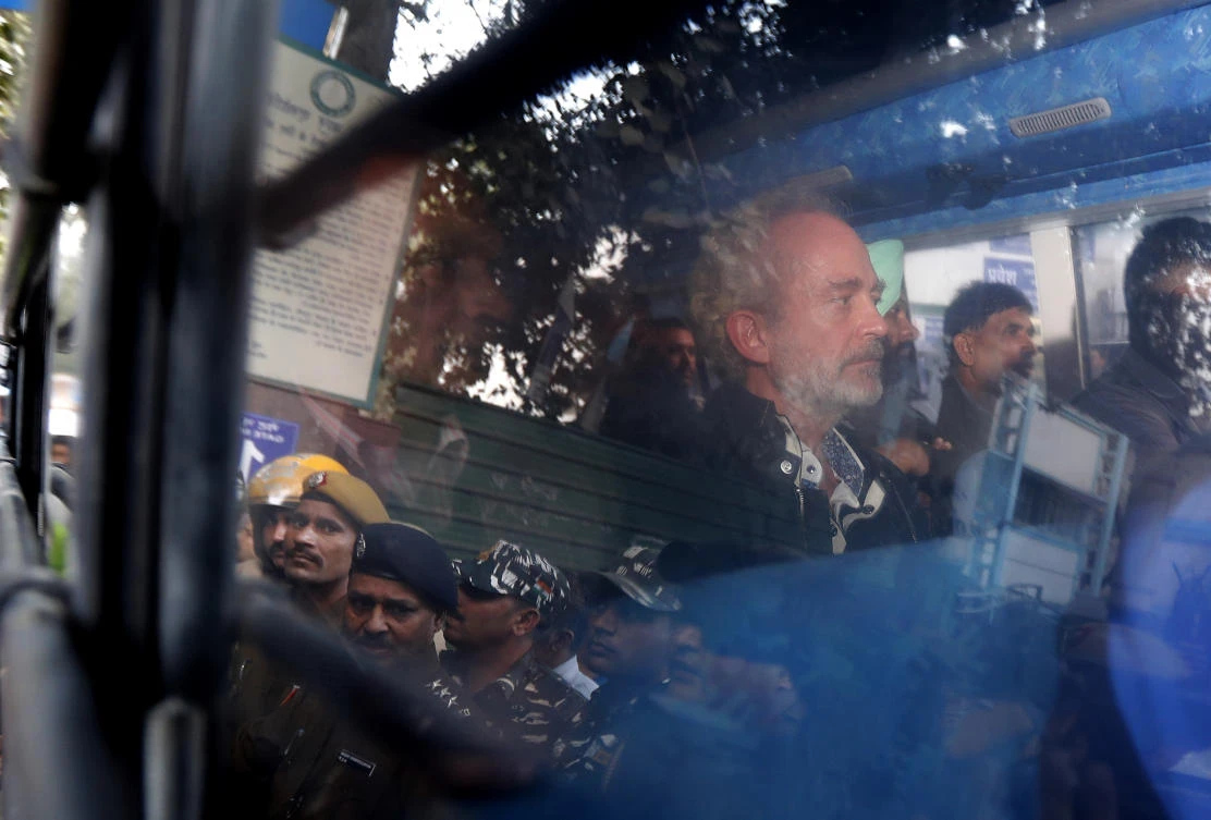Christian James Michel, center, a British man accused of bribery in a $670 million helicopter deal between India and an Italian defense company returns after appearing before a Central Bureau of Investigation court in New Delhi, India, Wednesday, Dec.5, 2018. (AP Photo/Altaf Qadri)