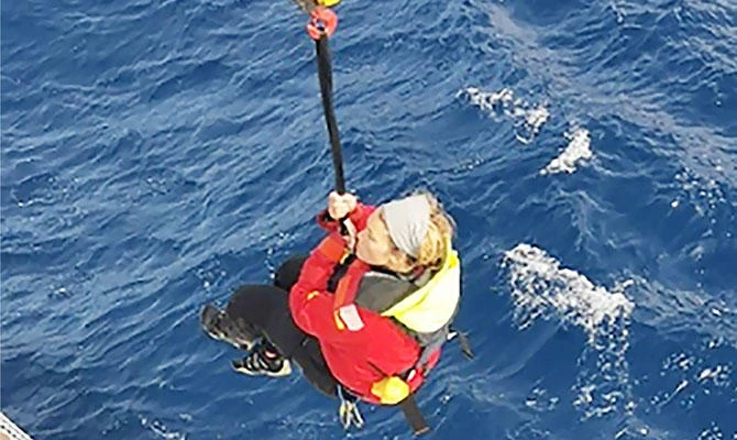 Handout photo released by the Chilean Navy's Maritime Rescue Coordination Centre (MRCC CHILE) showing the moment in which British yachtswoman Susie Goodall is being rescued by the Hong Kong-flagged vessel Tian Fu in Chilean jurisdiction waters in the Southern Ocean, after coordination between the MRCC, agencies and vessels, on December 7, 2018 a day after her yacht DHL Starlight was dismasted while on the Golden Globe Race. (AFP)