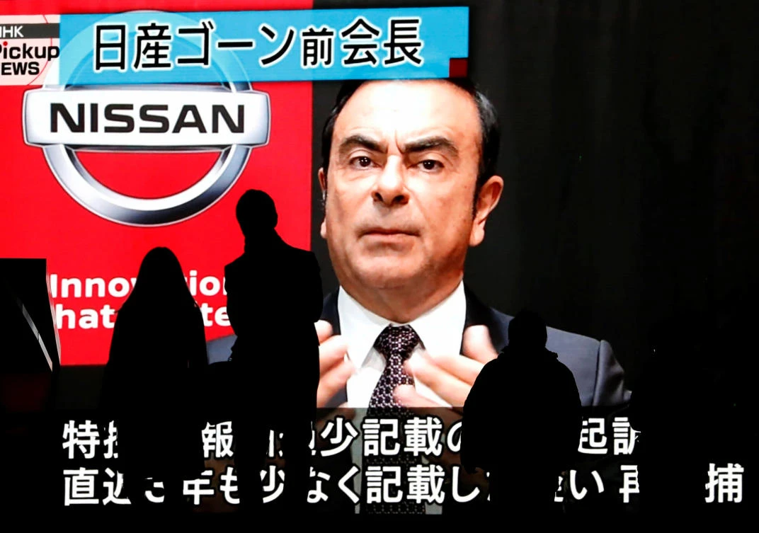 Passersby are silhouetted as a huge street monitor broadcasts news reporting ousted Nissan Motor chairman Carlos Ghosn's indictment and re-arrest in Tokyo, Japan December 10, 2018. (Reuters)