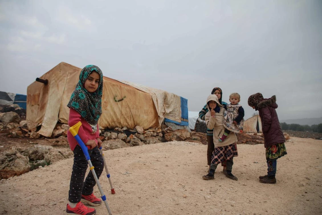Syrian Maya Merhi stands with her friends in the Internally Displaced Persons camp of Serjilla in northwestern Syria (File/AFP)