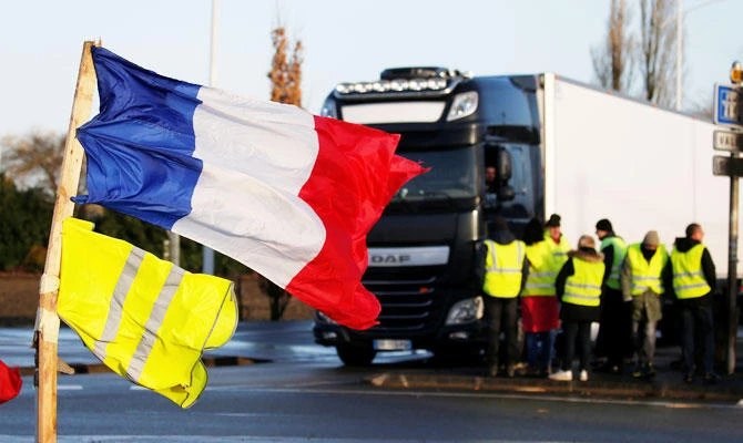 A French flag and a yellow vest fly near protesters wearing yellow vests who gather at a roundabout as part of a demonstration by the "yellow vests" movement in Somain, France, December 8, 2018. (REUTERS)