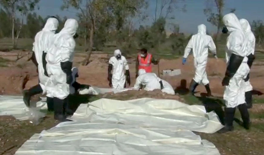 A video showing forensic experts in protective clothing recovering remains. (SANA)