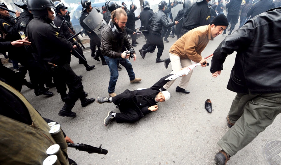 Demonstrators clash with Tunisian security force personnel on Rome Avenue in Tunis on Jan. 18, 2011. The resignation of three ministers rocked Tunisia’s fledgling unity government as protesters vented their anger at the new leadership just days after the ouster of the Arab state’s strongman. (AFP/file)