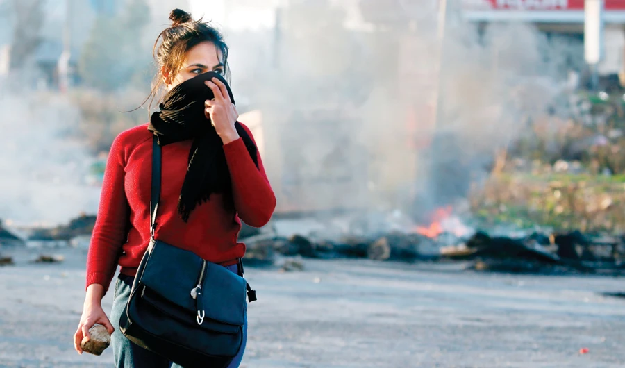 A protester covers her face during clashes with Israeli troops in Ramallah, near the Jewish settlement of Beit El, in the occupied West Bank on Thursday. (AFP)