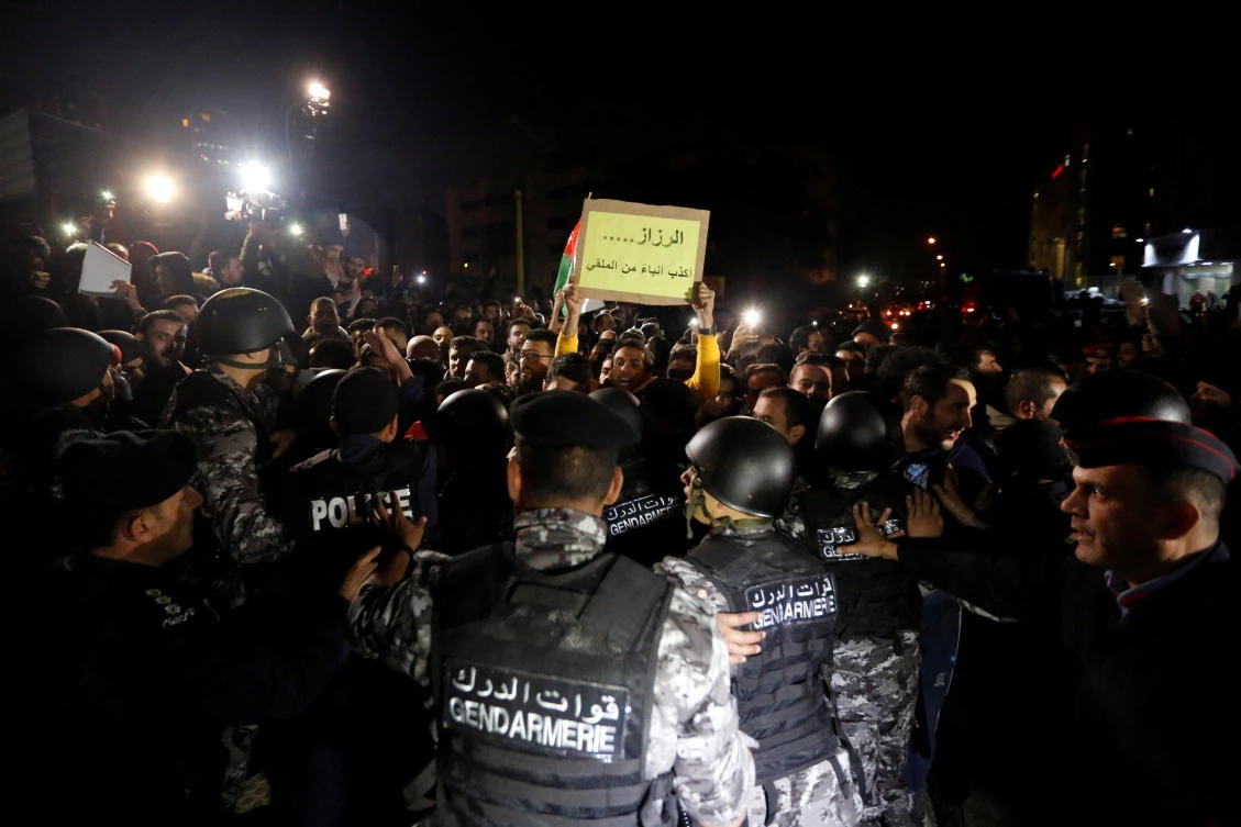 Protesters chant slogans during a protest against tax hikes in Amman, Jordan November 30, 2018. The sign reads “al-Razzaz is liar more than Al-Mulqi.” (Reuters)