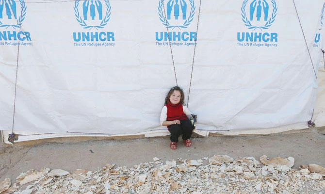 A Syrian refugee girl sits next to dried bread at a refugee camp in Akkar, northern Lebanon, on Nov. 27. (Reuters)