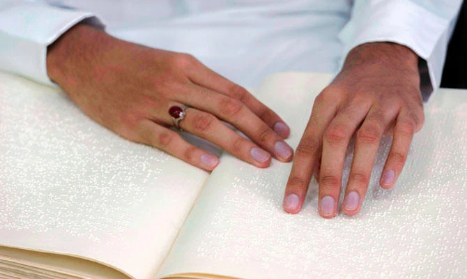A blind Saudi reads in braille a copy of the Quran, Islam's holy book, inside a mosque on the first day of the holy fasting month of Ramadan in the coastal town of Qatif, 400 kms east of Riyadh, on May 27, 2017. (AFP)