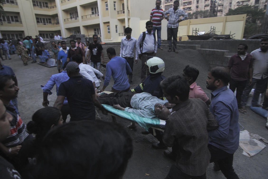 A rescued person is rushed out on a stretcher after a fire broke out at the five-story government-run ESIC Kamgar Hospital in Andheri, Mumbai, India, Monday, Dec.17, 2018. (AP Photo)