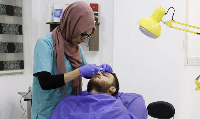 An Iraqi man gets a facial injection in the northern city of Mosul on October 30, 2018. (AFP)