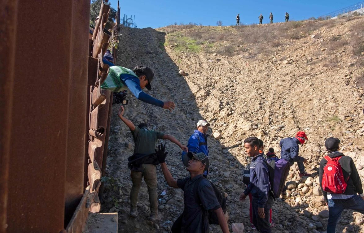 In this file photo taken on December 16, 2018, a group of Central American migrants - travelling in a caravan - are seen after crossing the Mexico-US border fence to San Diego County, from Tijuana, Baja California state, Mexico. (AFP)