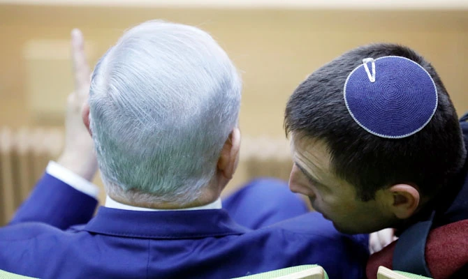 Israeli Prime Minister Benjamin Netanyahu chats to a member of the Israeli military before delivering a statement at the Knesset, Israel's parliament, in Jerusalem December 19, 2018. (REUTERS)