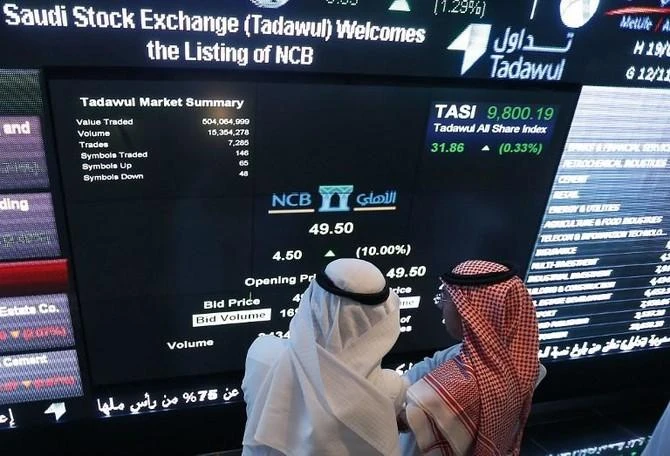 Saudi investors monitor stocks at the exchange market department at the National Commercial Bank (NCB) in Riyadh. (File photo/AFP)
