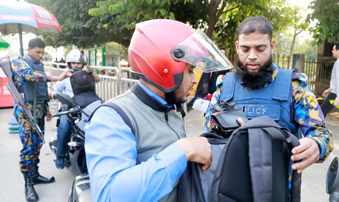Bangladeshi policemen check the bags of commuters in Dhaka, Bangladesh, Monday, Dec. 24, 2018. (AP)