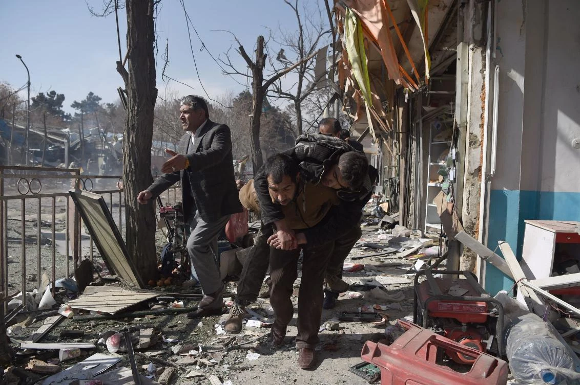 Afghan volunteers carry a body at the scene of a car bomb exploded in front of the old Ministry of Interior building in Kabul. (File/AFP)