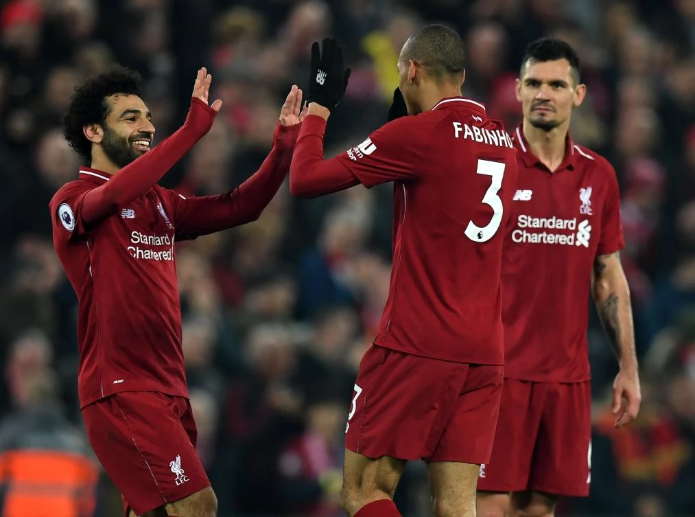 Liverpool's Brazilian midfielder Fabinho (C) celebrates with Liverpool's Egyptian midfielder Mohamed Salah (L) and Liverpool's Croatian defender Dejan Lovren (R) after he scores their fourth goal during the Premier League match between Liverpool and Newcastle United. (AFP)