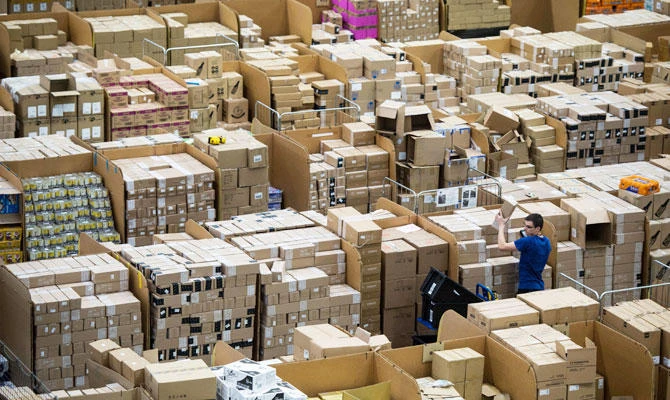 Workers prepare customer orders for dispatch as they work around goods stored inside an Amazon.co.uk fulfillment centre in Peterborough, central England, on November 15, 2017. (AFP)