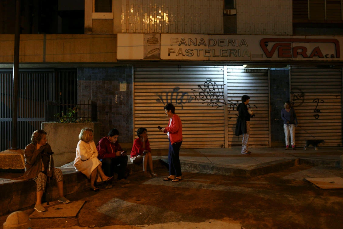 People stand on the street after an earthquake was felt across northern Venezuela, in Caracas. (Reuters)