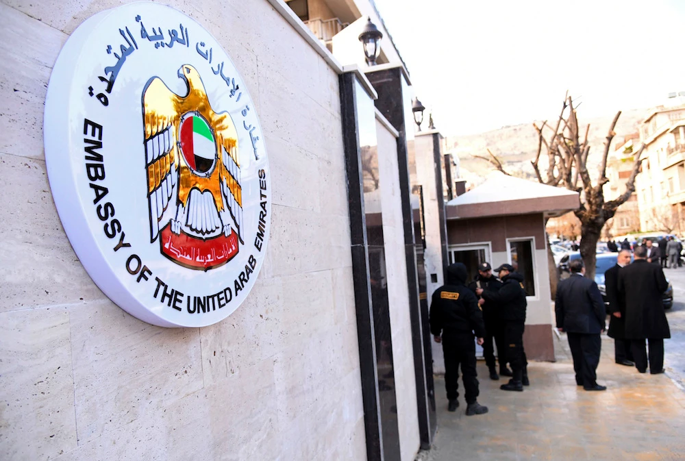 Officials gather outside the embassy of the United Arab Emirates, in Damascus on Thursday, Dec. 27, 2018. Syria said the UAE will reopen its embassy in Damascus on Thursday. (SANA via AP)