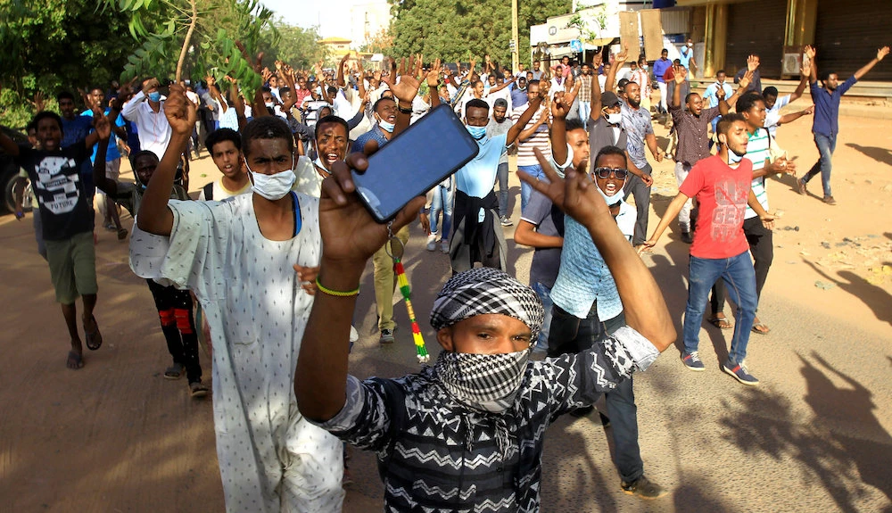 Sudanese demonstrators chant slogans as they march along the street during anti-government protests in Khartoum, Sudan December 25, 2018. (Reuters)