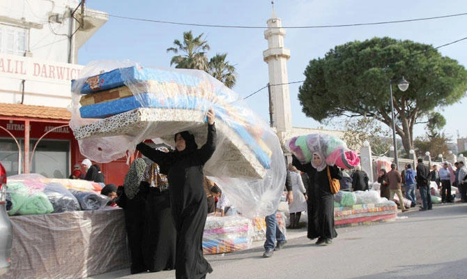 Syrian refugees receive aid from the UN refugee agency (UNHCR) in Batroun, northern Lebanon. (REUTERS file photo)