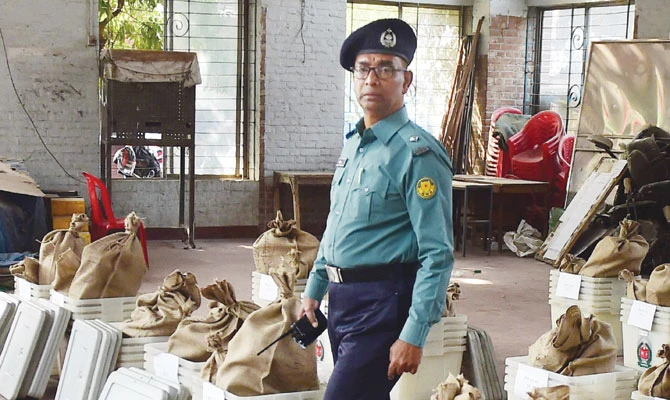 A policeman walks through polling material at a distribution center in Dhaka Saturday. (AFP)
