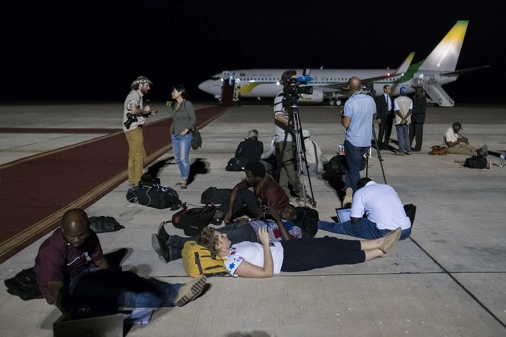 Journalists wait on the tarmac of the Banjul airport on January 20, 2017 as outgoing Gambian President Yahya Jammeh negotiates a deal where he would live out his exile. (AFP)