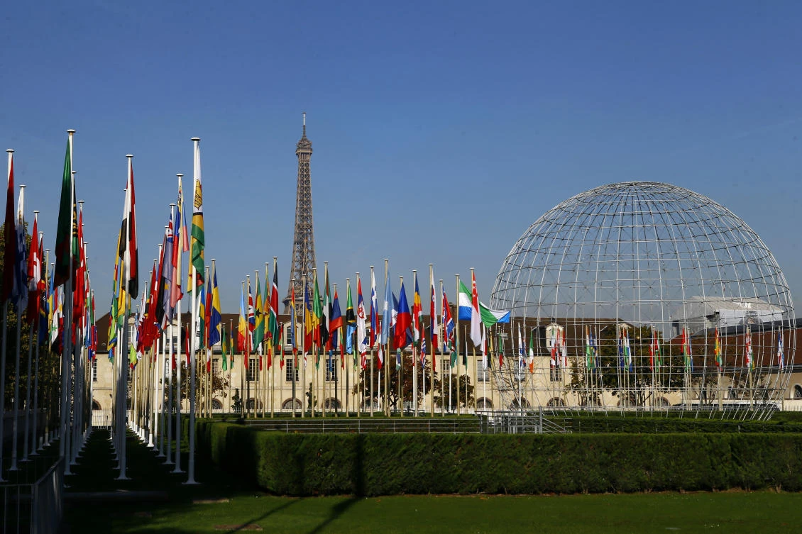 In this Tuesday Oct. 31, 2017 file picture, the Eiffel Tower, country flags and the Dome are seen from the garden of the United Nations Educational, Scientific and Cultural Organisation (UNESCO) headquarters building during the 39th session of the General Conference at the UNESCO headquarters in Paris, France. (AP)