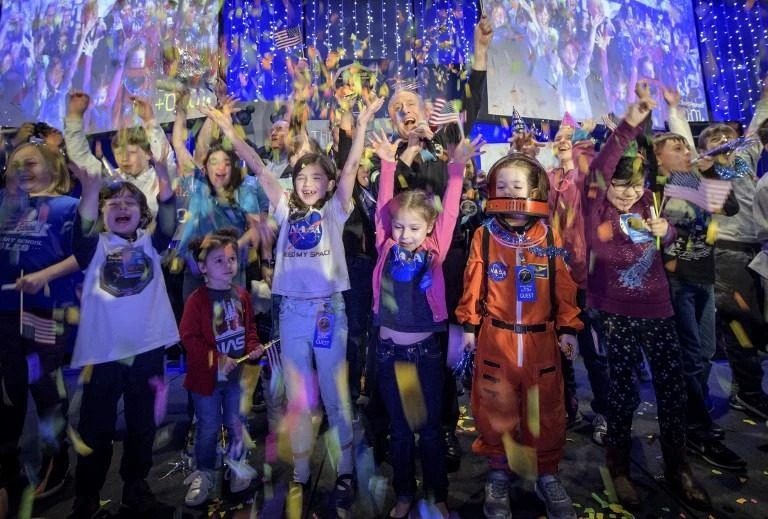 New Horizons principal investigator Alan Stern, center, celebrate with school children at the exact moment that the New Horizons spacecraft made the closest approach of Kuiper Belt object Ultima Thule on January 1, 2019. (NASA/AFP)