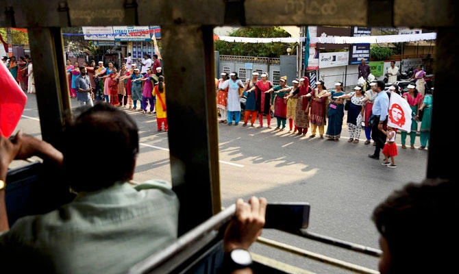 Women raise their hands to take a pledge to fight gender discrimination as they form part of a hundreds kilometer long "women's wall" in Thiruvananthapuram, in the southern Indian state of Kerala, Tuesday, Jan. 1, 2019. (AP)