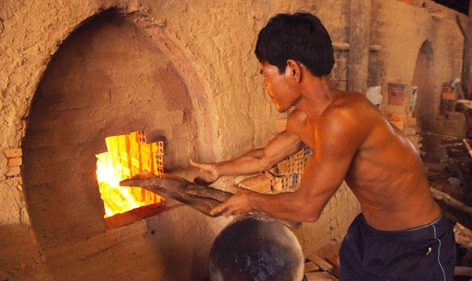 This photograph taken on December 11, 2018 shows a Cambodian labourer working at a brick factory on the outskirts of Phnom Penh. Saddled with debt from failed harvests, tens of thousands of farmers are turning to brick factories, where owners pay off their bills in exchange for labour. (AFP)