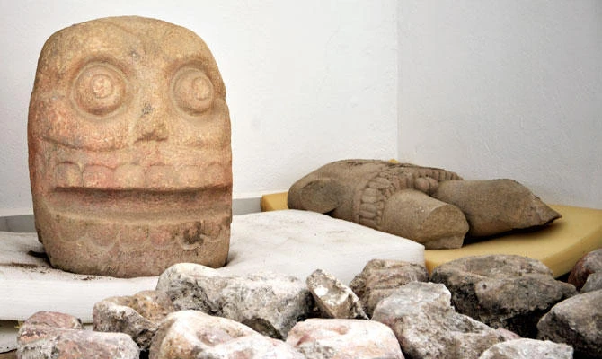 In this 2018 photo provided by Mexico's National Institute of Anthropology and History, INAH, a skull-like stone carving and a stone trunk depicting the Flayed Lord, a pre-Hispanic fertility god depicted as a skinned human corpse, are stored after being excavated from the Ndachjian-Tehuacan archaeological site in Tehuacan, Puebla state, where archaeologists have discovered the first temple dedicated to the deity. (AP)